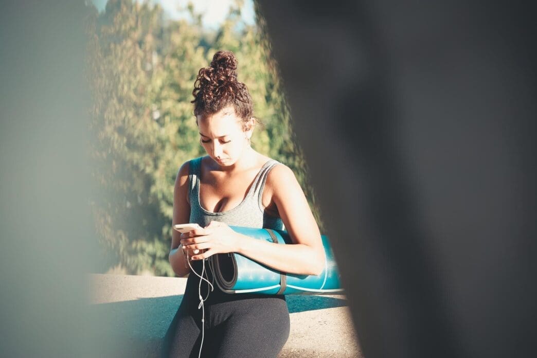 A young woman stands with her back to the camera, gazing towards the sky.