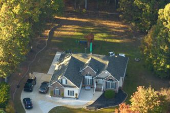 Aerial view of a large, traditional American home with a manicured lawn in a suburban South Carolina neighborhood.