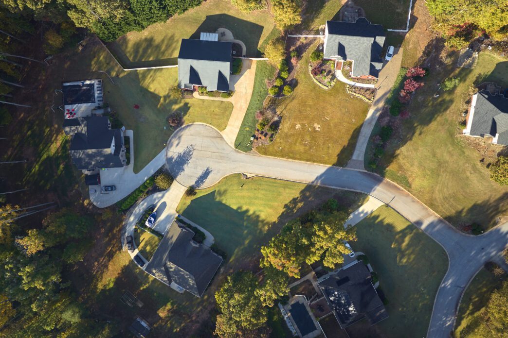 Aerial view of newly-built family houses nestled among yellow trees in a South Carolina suburban neighborhood during the fall.