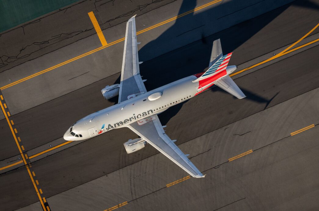 Aerial view of an American Airlines passenger plane taxiing on the tarmac at a major airport.