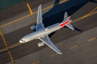 Aerial view of an American Airlines passenger plane taxiing on the tarmac at a major airport.