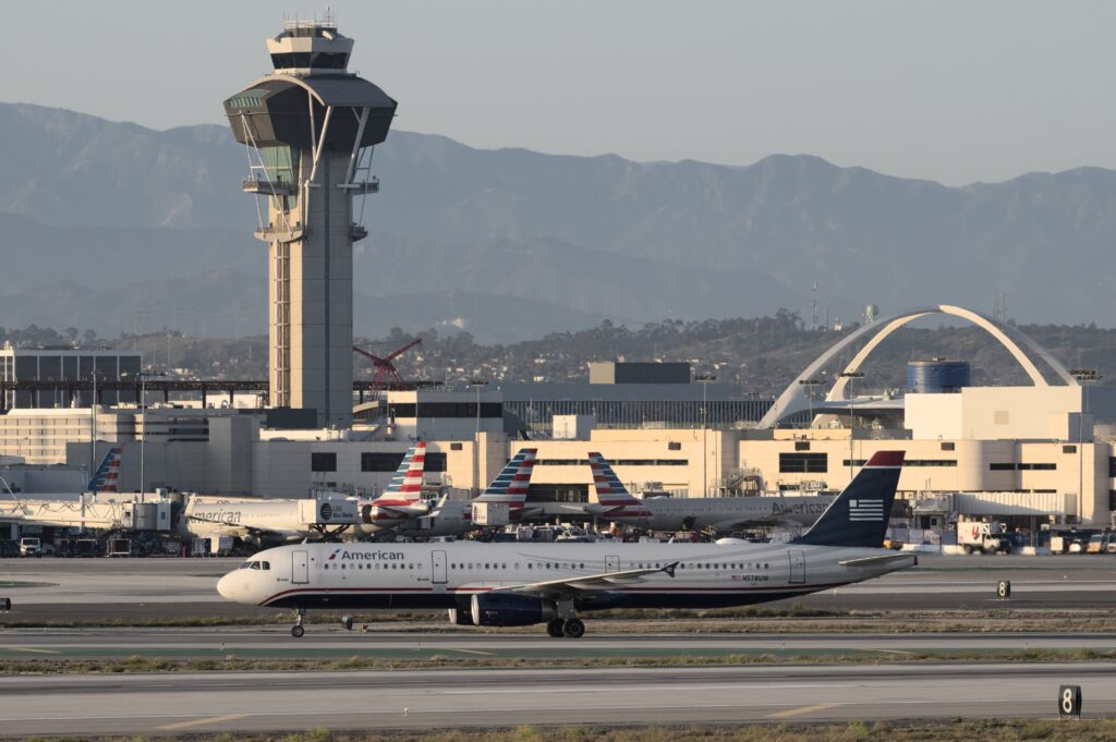American Airlines Airbus A321 taxiing in US Airways livery past the LAX control tower.