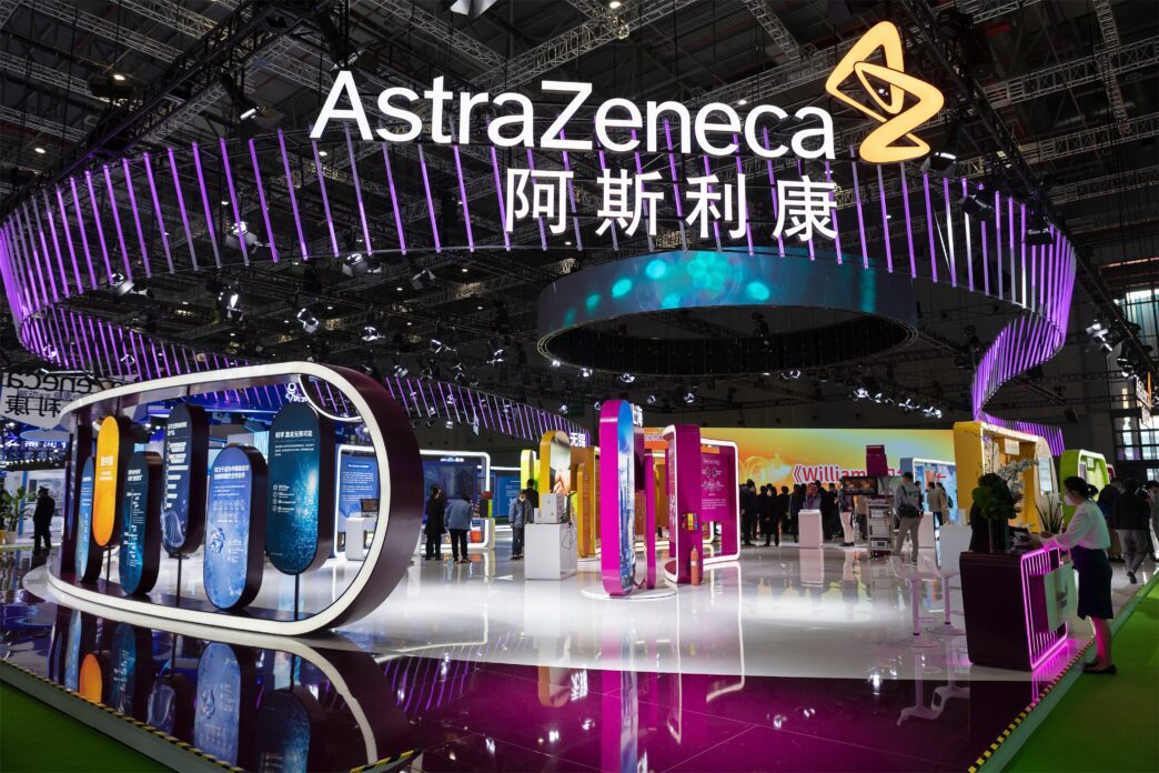 People viewing the large, illuminated AstraZeneca booth at the China International Import Expo.