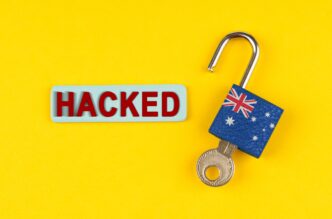 Unlocked padlock covered with the Australian flag next to a blue sign with the word "HACKED."