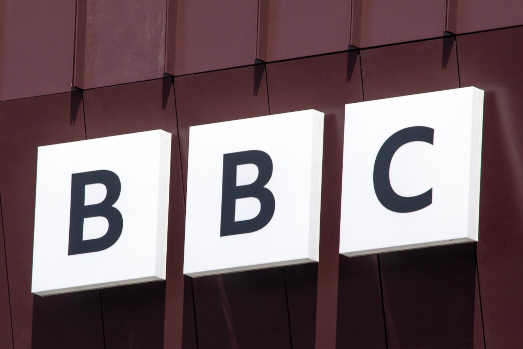 Close-up of the iconic BBC logo (three white boxes with black letters) on a building facade.