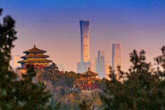 Beijing cityscape contrasting ancient pagodas with modern skyscrapers at sunset.