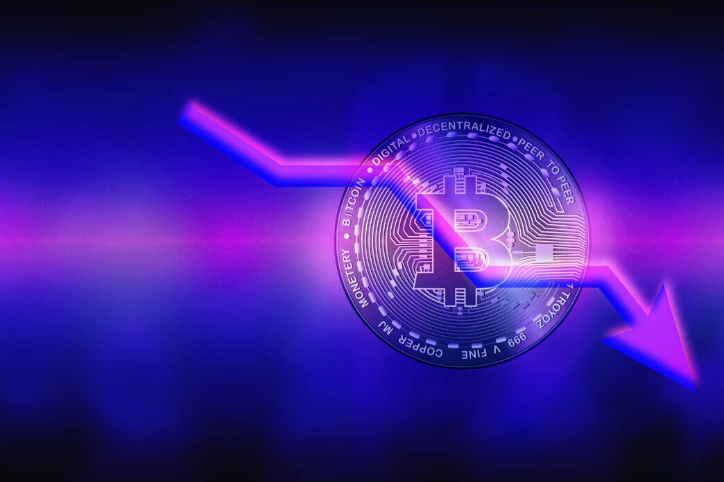 Digital Bitcoin coin with a glowing neon arrow pointing down, symbolizing a price collapse.