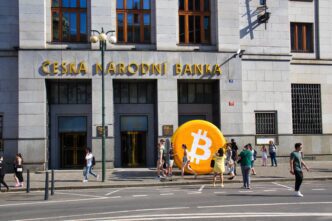 Giant inflatable Bitcoin symbol placed in front of the Czech National Bank (ČNB) building entrance.