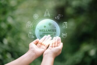 Hands holding a glowing digital sphere labeled "WELLNESS LONGEVITY" surrounded by health icons.