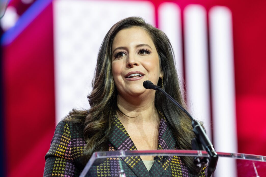 Close-up of Congresswoman Elise Stefanik speaking at a microphone at the CPAC conference.