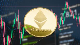 Gold Ethereum coin centered over a screen displaying a green and red candlestick trading chart.