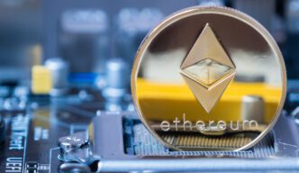 Gold Ethereum coin resting on the CPU socket of a computer motherboard.