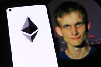 Smartphone displaying the Ethereum logo next to a blurred image of co-founder Vitalik Buterin.