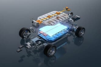 Exploded view rendering of an electric vehicle chassis showing the glowing blue battery pack, wheels, and drivetrain components.