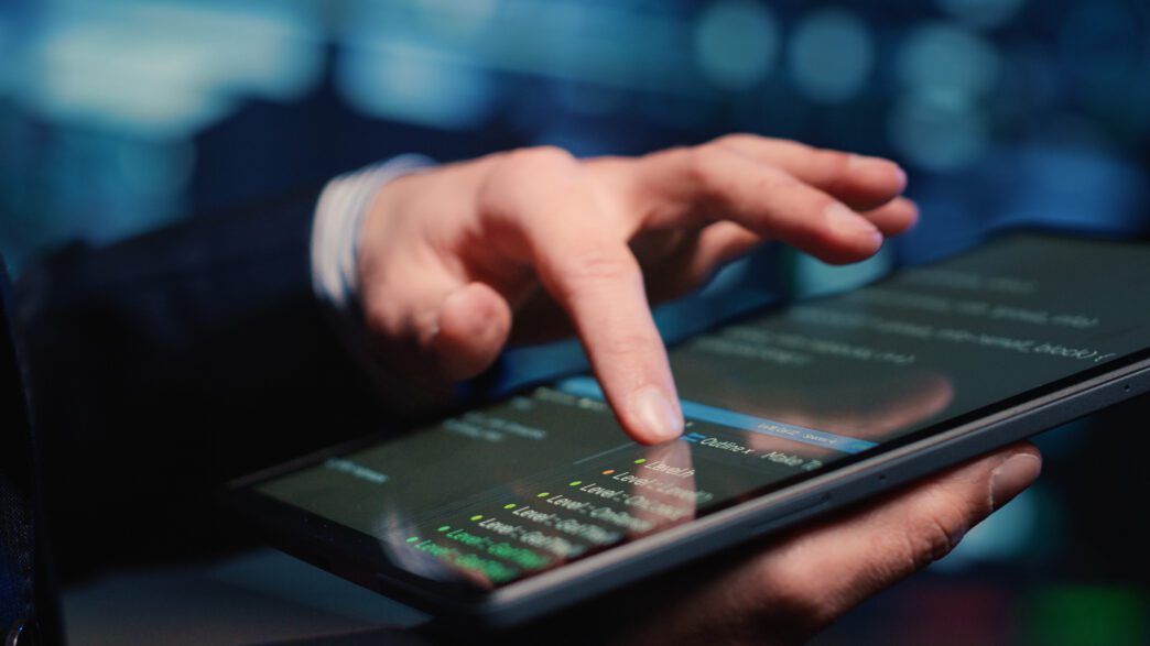 Close-up of a hand interacting with code on a tablet, symbolizing a FinTech data specialist.