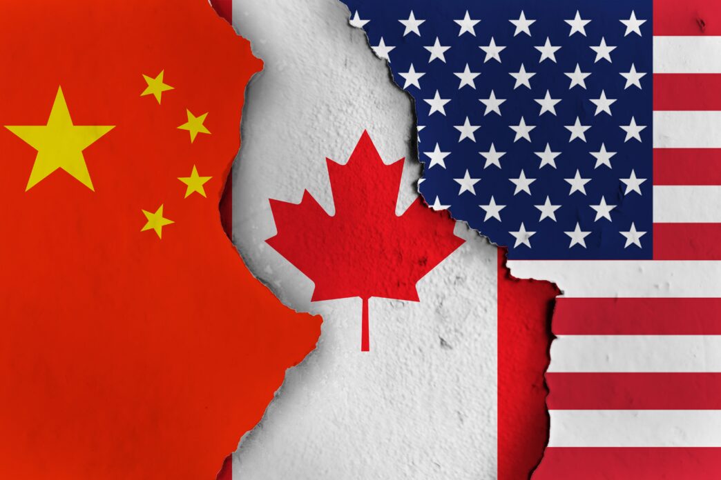 Ripped flags of China and the USA revealing the flag of Canada underneath, symbolizing conflict.
