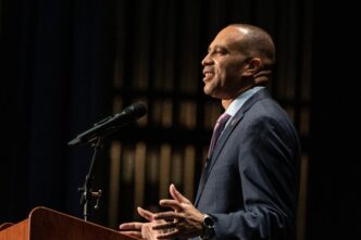 Congressman Hakeem Jeffries speaking passionately at a podium during an event.