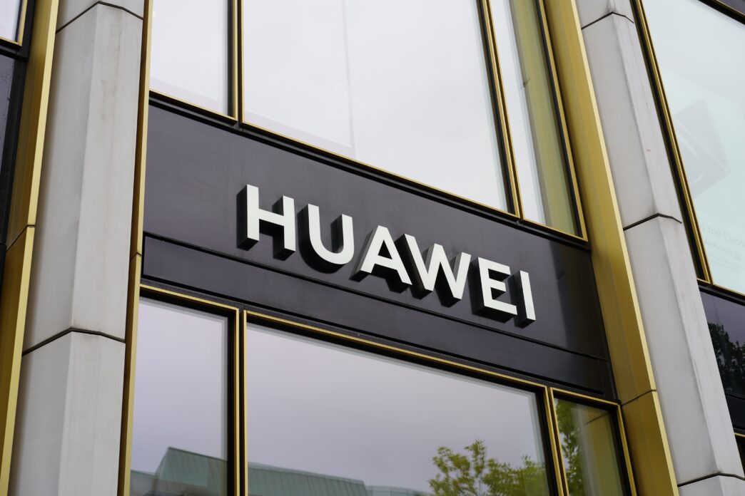 Close-up of the Huawei company logo sign on the exterior of a modern office building.