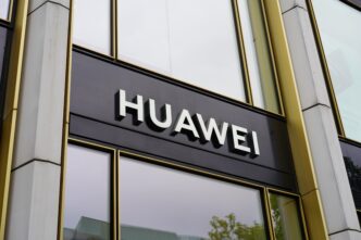 Close-up of the Huawei company logo sign on the exterior of a modern office building.