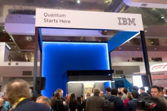 IBM trade show booth with a sign reading "Quantum Starts Here" above a glowing blue wall.