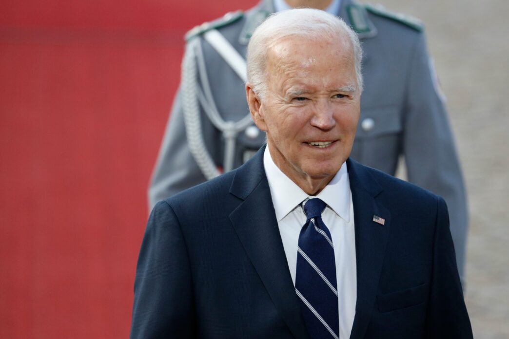 Close-up of Joe Biden smiling while being received with military honors in Berlin.
