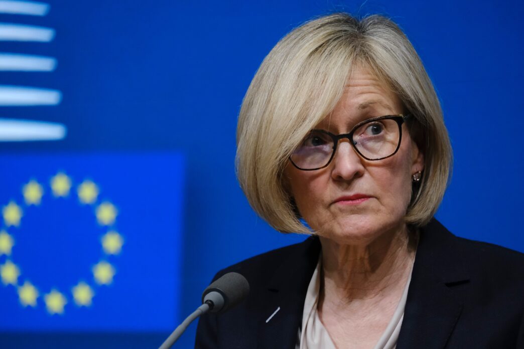 Close-up of Mairead McGuinness speaking at a press conference with the EU flag in the background.