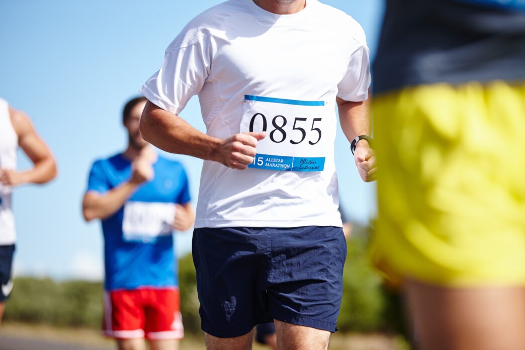 Close-up of a marathon runner wearing a white shirt and bib number 0855.