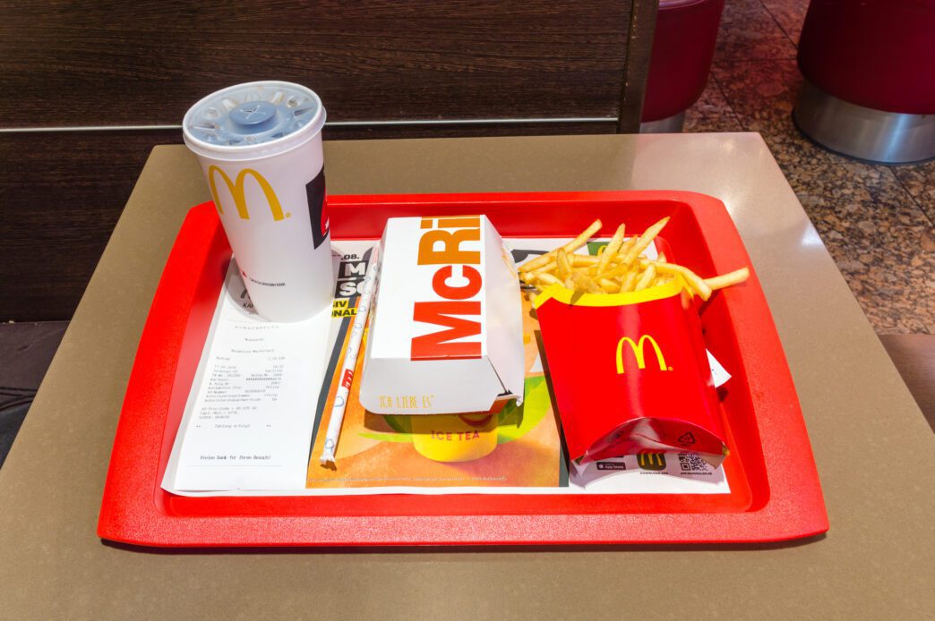 McDonald's McRib meal with a sandwich, french fries, and a soda cup on a red tray.
