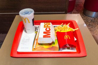 McDonald's McRib meal with a sandwich, french fries, and a soda cup on a red tray.