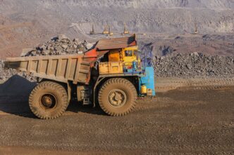 Large, old mining haul truck loaded with rocks in a quarry extraction site.