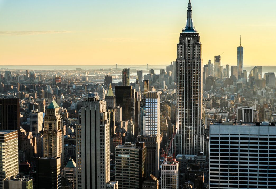Aerial view of the New York City skyline featuring the Empire State Building at sunset.