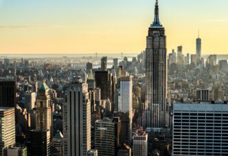 Aerial view of the New York City skyline featuring the Empire State Building at sunset.