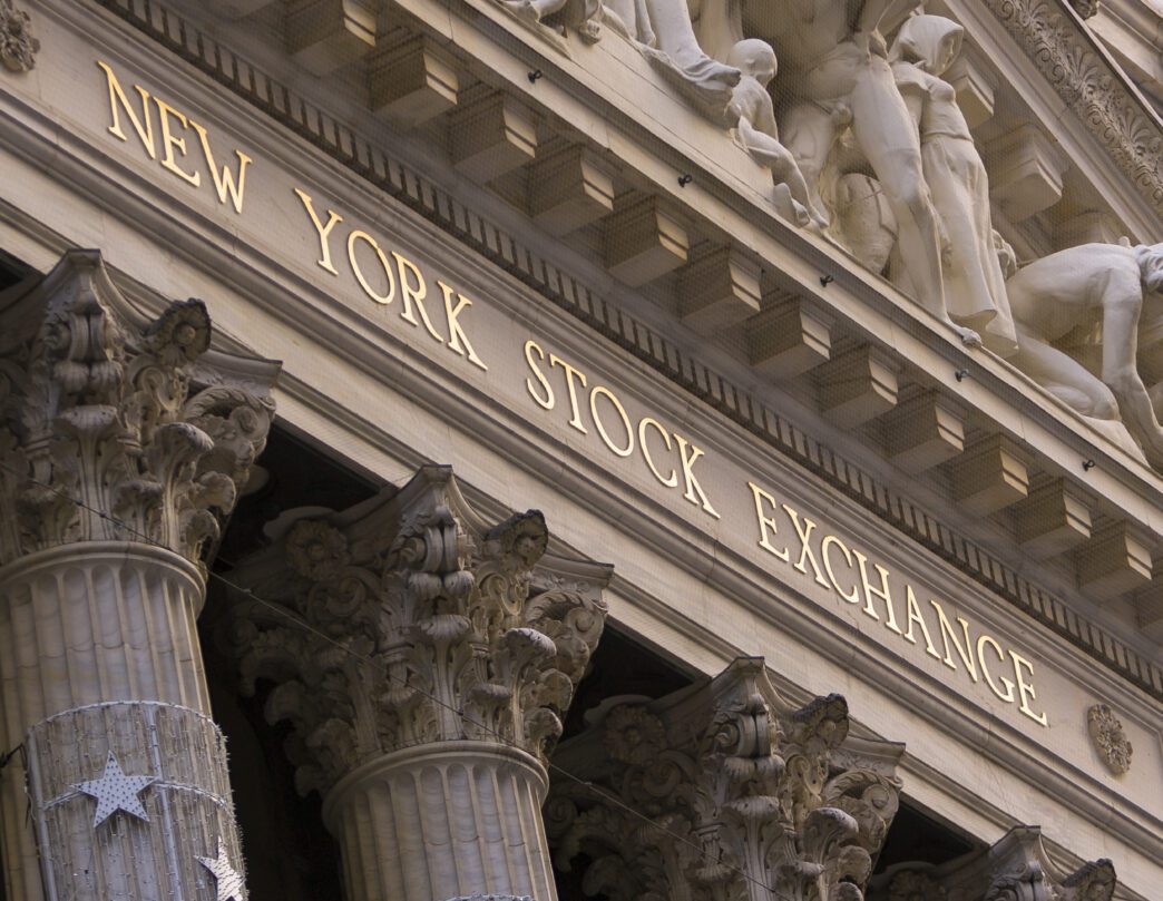 Close-up of the New York Stock Exchange facade with gold lettering and columns.