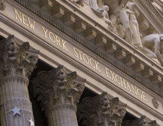 Close-up of the New York Stock Exchange facade with gold lettering and columns.