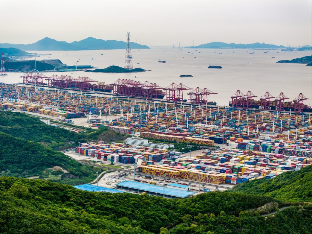 Aerial view of the immense Ningbo-Zhoushan container port, cranes, and hundreds of shipping containers.