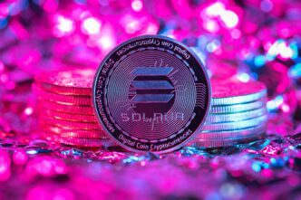Solana (SOL) cryptocurrency coin in vibrant magenta and cyan lighting against stacks of coins.