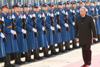 Russian President Vladimir Putin walking past a line of Serbian ceremonial guards.