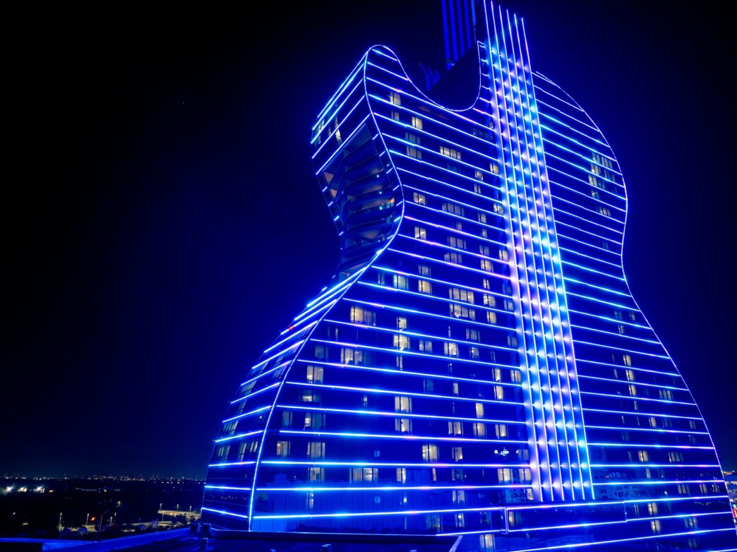Seminole Hard Rock Guitar Hotel lit up brightly with neon blue lights at night.