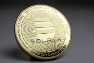 Macro shot of a physical gold Solana coin, showing its logo and digital design details.