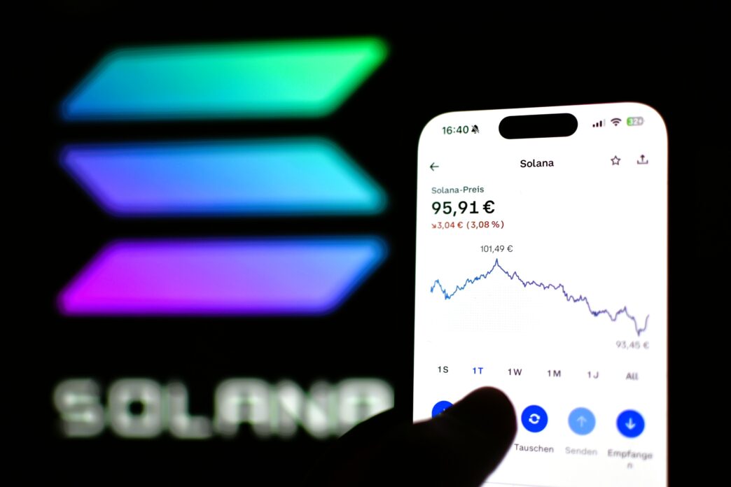 Coinbase app showing Solana's price chart on a phone, with the Solana logo in the background.