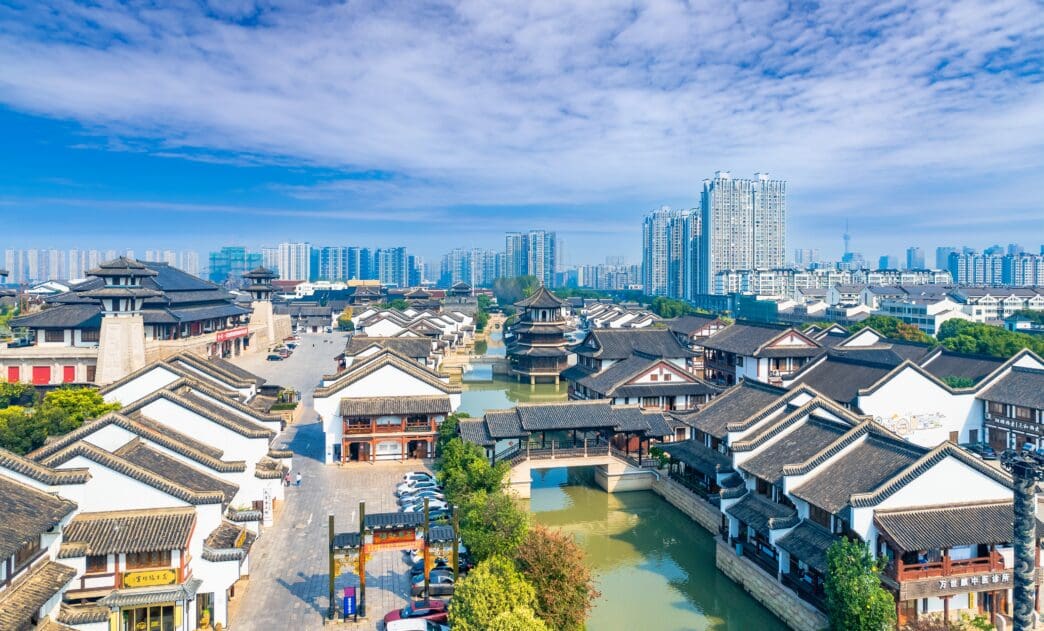Aerial view of the traditional Spring and Autumn Yancheng tourist area with modern high-rise buildings in the distance.
