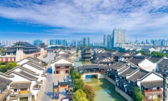 Aerial view of the traditional Spring and Autumn Yancheng tourist area with modern high-rise buildings in the distance.