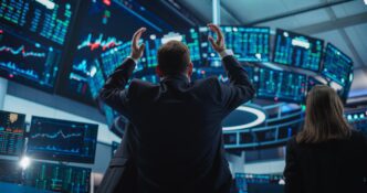 Depressed stock trader in a suit with hands raised in frustration, surrounded by multiple monitors displaying negative financial data.