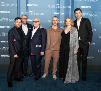Six main cast members of the TV show Succession posing on a blue carpet at a premiere event.