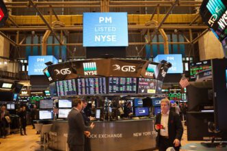 Interior view of the New York Stock Exchange floor with the central trading desk, digital screens, and traders.