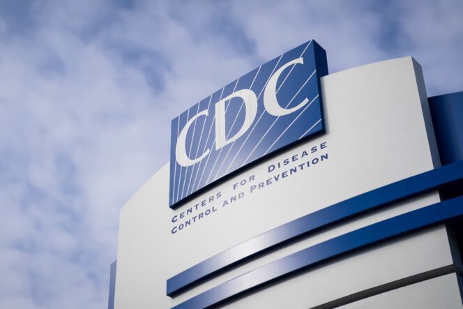 Low-angle shot of the modern sign for the Centers for Disease Control and Prevention (CDC) against a cloudy sky.