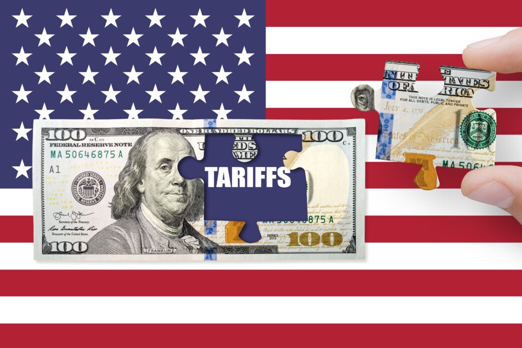 Puzzle piece with the word "TARIFFS" being removed from a $100 bill overlaid on the US flag.