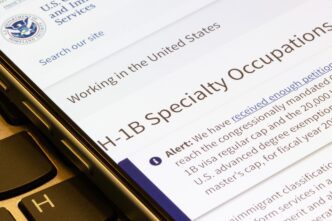 Smartphone screen displaying the U.S. Citizenship and Immigration Services H-1B Visa webpage.