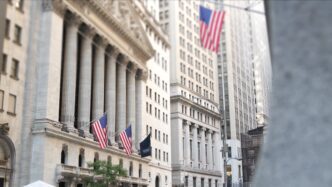 New York Stock Exchange building facade with US flags in Lower Manhattan's Financial District.