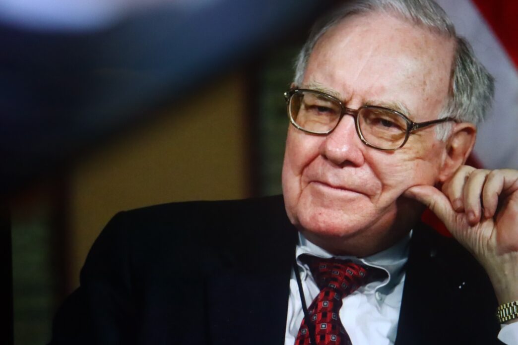 Close-up portrait of billionaire investor Warren Buffett, wearing glasses and resting his chin on his hand.